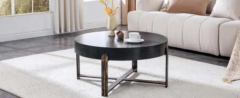 Round coffee table (68 cm diameter) in a retro-industrial style.MDF tabletop with a black wood-effect finish and a metal cross-base in an antique bronze tone; suitable for Wabi-Sabi or industrial-style interiors. Side table.